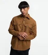 Camisa marrón de manga larga, confeccionada en sarga, con cuello inglés, abotonado delantero, bolsillos en el pecho con solapa y puños abotonados.