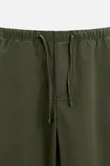 Pantalón de hombre color beige, corte carrot fit, con cintura elástica ajustable con cordón, bolsillos frontales y bolsillo trasero de plastrón.