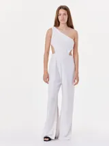 Mono blanco de lino con un solo hombro y detalles cut-out en los costados.