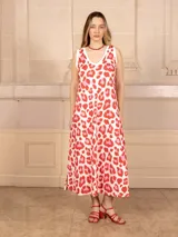 Vestido midi sin mangas con estampado animal print en tonos rojo y rosa sobre fondo blanco. Tiene escote en V y corte evasé.