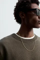 Jersey negro de corte boxy fit, tejido en hilatura con mezcla de algodón y 13% de cashmere. Tiene cuello redondo, manga larga y acabados en rib.