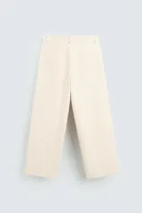 Pantalón negro de corte amplio, tipo balloon fit, con pinzas en la cintura, bolsillos laterales y traseros de ojal.
