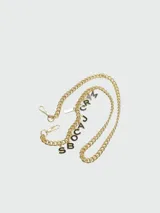 Correa de cadena dorada para cartera Marc Jacobs, con mosquetones en los extremos y letras colgantes con el nombre de la marca.