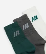 Kit de tres pares de medias de caña media New Balance, en colores gris, blanco y verde oscuro. Cada media tiene el logo de la marca bordado en el lateral.