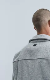 Chaqueta gris melange de paño con cuello clásico, cierre frontal con botones negros, dos bolsillos de parche en el pecho y dos bolsillos laterales.