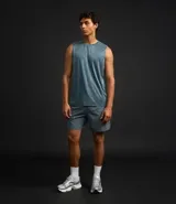 Bermuda deportiva gris con textura perforada, cintura elástica con cordón ajustable y corte holgado.