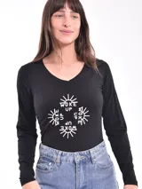 Remera blanca de manga larga con cuello redondo y estampado abstracto en tonos pastel.