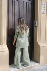 Blazer verde seco de lino, con corte entallado, solapas clásicas y cierre frontal con botones.