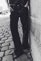 Pantalón jean negro de tiro alto, corte ancho y recto, con cinco bolsillos y cierre con botón.