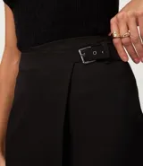 Short pollera de estilo sastre, color camel/marrón claro, con diseño de traspaso frontal asegurado por una hebilla.