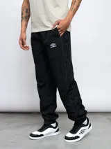 Pantalón deportivo negro de nylon con detalles en contraste blanco y logo de Umbro bordado en el lateral. Corte relajado.