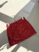 Minifalda roja cubierta de lentejuelas, con cintura elástica y abertura lateral.