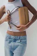 Bolso bandolera color caramelo, con doble asa: una asa larga regulable y una asa de hombro. Tiene bolsillo interior con cierre mediante cremallera metálica y solapa con cierre imantado.
