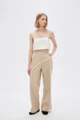 Pantalón de lino color beige, de corte recto y tiro alto, con bolsillos laterales.