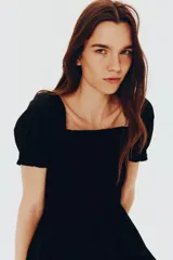 Vestido corto negro de popelina de algodón con escote cuadrado y mangas cortas abullonadas con elástico. El cuerpo es ajustado con fruncido y la falda con vuelo. Tiene ribete de volado en escote y puños.