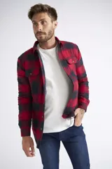 Sobrecamisa de viyela para hombre con estampado de cuadros en rojo y negro. Presenta cierre frontal con botones, bolsillos en el pecho con solapa y botón, y un interior capitoneado para mayor abrigo. Cuenta con un logo en grifa de cuero.