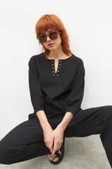 Remera color crudo con cuello redondo y mangas 3/4 abullonadas.