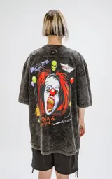 Remera negra con efecto nevado, corte oversize y estampado de Pennywise, globos y la frase 'Todos Flotan'.