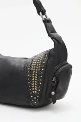 Cartera tipo hobo de cuero vacuno color negro, con apliques de tachas doradas y plateadas. Tiene un asa corta trenzada y dos bolsillos externos con cierre.