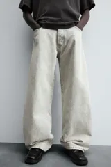 Pantalón de jean negro de corte amplio, estilo balloon fit, con cinco bolsillos y cierre frontal con botones.