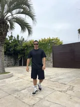 Conjunto negro tejido calado, compuesto por una remera de corte cuadrado y shorts.