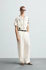 Camisa de manga corta con cuello bowling y estampado floral en tonos blanco y negro.
