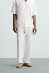 Pantalón azul marino de corte recto, con cintura elástica ajustable con cordón, bolsillos laterales y traseros.