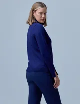 Polera de punto fino marca Nienty, color blanco, con cuello alto volcado y mangas largas con detalle de tajo en los puños.