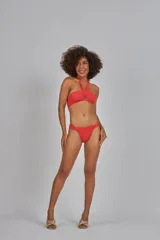 Bikini top rojo con diseño asimétrico y detalles de corte en la parte frontal.