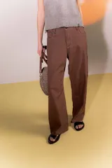 Pantalón marrón de lino rústico, con calce recto y tiro medio. Tiene bolsillos delanteros y traseros.