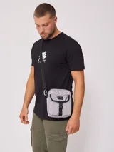 Bandolera gris de nylon con correa negra ajustable y logo Rusty estampado en negro.