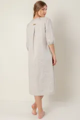 Vestido azul de lino, corte recto, largo midi, escote en V, manga corta, bolsillos laterales y tajos en los laterales.