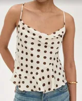 Blusa de tirantes color blanco con estampado de lunares marrones, escote drapeado y corte asimétrico.