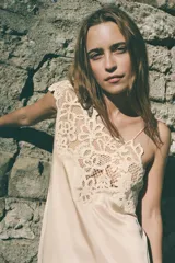 Vestido midi color beige, de viscosa, con escote asimétrico y detalle de crochet en el hombro.