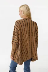 Sweater holgado de algodón tejido, con diseño de trenzas en color fucsia y detalles en azul, puños altos ajustados y bolsillos.