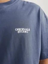 Camiseta azul de manga corta y cuello redondo con logo "Originals Studio" estampado en el pecho.