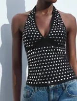 Top negro con cuello halter y espalda descubierta, con apliques de lentejuelas plateadas.