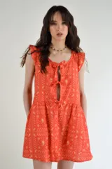 Vestido corto color naranja con estampado de cachemir en amarillo, escote redondo con lazos ajustables, mangas cortas con volados y falda con volados.