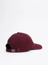 Gorra de béisbol color bordó con el logo de Tommy Hilfiger bordado en blanco en el frente y el logo de la marca en la parte trasera.