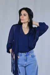 Camisa azul de mangas largas con cuello en V y lazo con flecos.