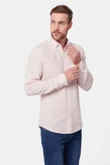 Camisa de lino color beige, de manga larga, con cuello clásico y bolsillo en el pecho.