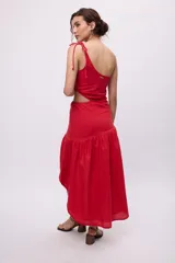 Vestido largo rojo de algodón y lino, con un hombro descubierto, bretel fino con lazo, recorte en la cintura y falda asimétrica con volados.