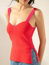 Top rojo de punto jacquard, corte ajustado, con breteles fucsia, tajos laterales y cierre en la espalda.