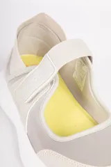 Zapatilla tipo guillermina negra con elástico en el tobillo y velcro. Cuenta con recortes en diferentes tonos y telas y plataforma de 3cm de alto.