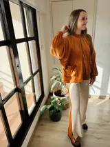Campera oversize color marrón, con cierre frontal y bolsillos en la parte frontal.