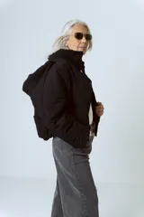 Campera negra de estilo acolchado con cierre frontal y cuello alto.