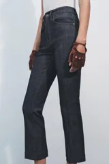 Pantalón de jean de tiro alto color negro con pierna ancha, bolsillos delanteros y traseros, y cierre frontal con cremallera y botón metálico.