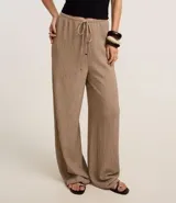 Pantalón wide leg color beige con textura, cintura elástica con cordón ajustable y bolsillos laterales.