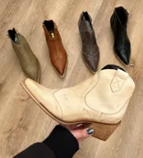 Bota texana de caña baja color marrón con efecto vintage, confeccionada en cuero vacuno y forrada en cuero. Tiene taco de 5cm y cierre lateral.