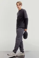 Remera negra de algodón pesado, corte holgado, con cuello redondo ribeteado, hombros caídos y bajo recto.